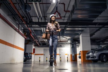 Elektrikli scooter kullanan kendinden emin mutlu bir kadın işe gidiyor..