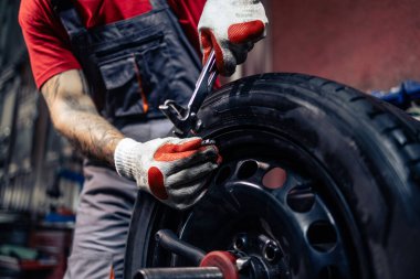 Lastik tamircisi tekerleği dengelemek için biraz ağırlık ekliyor..