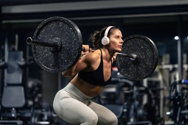 Spor salonunda kaslı, formda bir kadın halter..