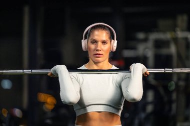 Güçlü beyaz kadın spor salonundaki halter ağırlık kaldırma eğitimine odaklanmış..