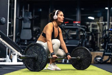 Kadın sporcu halter ağırlık kaldırmaya ve ağırlık kaldırmaya odaklanmış..