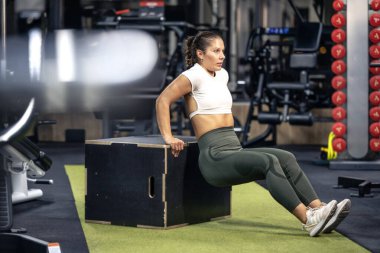 Spor salonunda egzersiz yapan kaslı bayan sporcu..