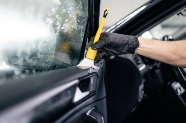 Araba içerisindeki detayları temizlemek için fırça kullanan profesyonel temizleyici.
