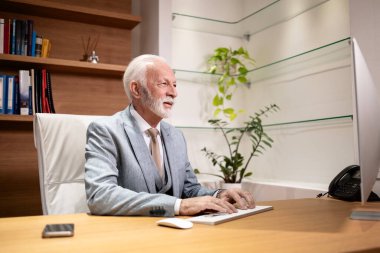 Şirket genel müdürü ofisinde çok çalışıyor. Masaüstü bilgisayarı kullanılıyor.