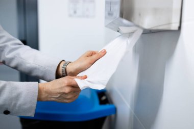 Ellerini yıkadıktan sonra kağıt havlu kullan. Tuvalette el üstünde kağıt havlu kullanarak insan eli görüntüsünü kapat..