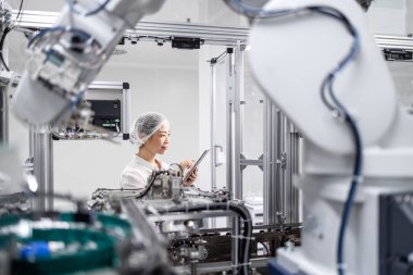 İleri teknoloji fabrikasında çalışan bir mühendis. Otomatik robot üretim hattında çalışan ve modern endüstriyel makinenin üretim sürecini kontrol eden ve izleyen Japon mühendis. Robotik kol elektronik ekipman üretimi.