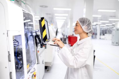 Fabrika üretim hattındaki makine bilgisayarında çalışan çalışkan Japon işçiler. Gelişmiş elektronik teknoloji fabrikasında çalışıyor..