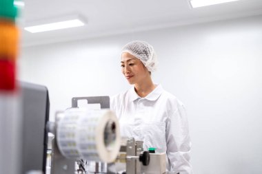 Japon kalite kontrol işçisi üretim hattı fabrikasında barkod tarayıcı ile elektronik parçaları onaylıyor. Elektronik üretim fabrikasında ürün onayı ve kalite kontrolü.