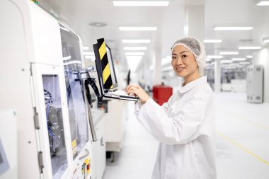 Fabrika üretim hattındaki makine bilgisayarında çalışan çalışkan Japon işçiler. Gelişmiş elektronik teknoloji fabrikasında çalışıyor..