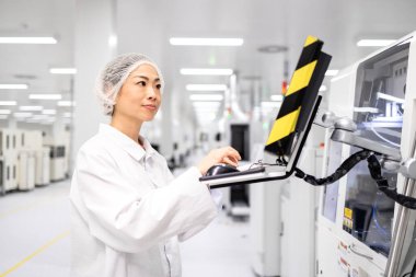 Doğu Asyalı mühendis, elektronik endüstrisi için gelişmiş teknoloji fabrikasında endüstriyel makine çalıştırıyor..