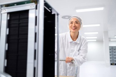 Veri merkezi sunucu odasında çalışıyorum. Japon bakım mühendisi sunucu odasında sabit disk depolama ortamı olan el arabasını itiyor.