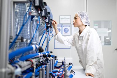 Mekanik mühendisi araştırma ve geliştirme fabrikasında prototip makinesinin yanında duruyor..