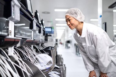 Otomobil endüstrisi için kablo üretimini kontrol eden kadın Japon işçiler.