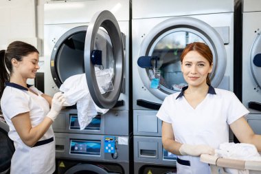 Kuru temizleme servisi. Kirli çamaşırları yıkayacak kadın işçiler.