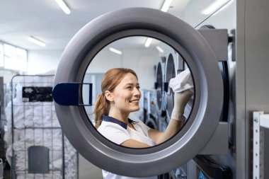 Beyaz kadın çamaşırcı. Yıkanmak için havlu ve çarşaf hazırlıyor..