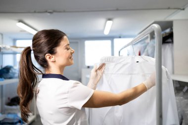 Kuru temizleme servisindeki müşteriler için temiz giysiler asan kadın çamaşırcı..