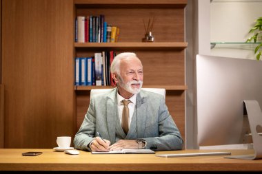 Şirket genel müdürü ofisinde çok çalışıyor. Masaüstü bilgisayarı kullanılıyor.