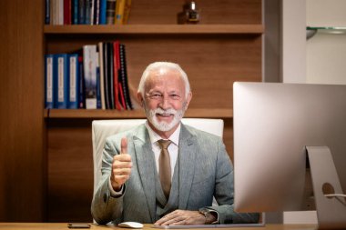 Ofisinde oturmuş gülümseyen yakışıklı işadamının portresi..