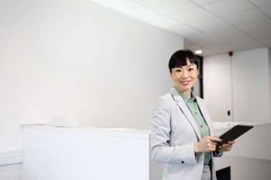 Japon iş kadını. Ofisinde duruyor..