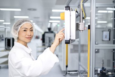 Modern teknoloji endüstrisinde üretim sürecini kontrol eden Japon fabrika işçisi.