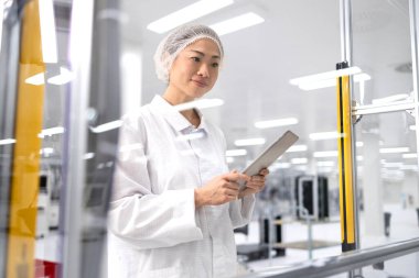 Fabrika üretim hattındaki makine bilgisayarında çalışan çalışkan Japon işçiler. Gelişmiş elektronik teknoloji fabrikasında çalışıyor..