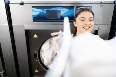 Üniformalı kadın işçi çamaşırları yıkıyor..