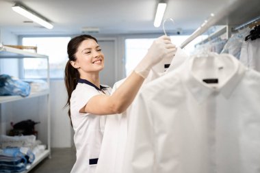 Kuru temizleme servisindeki müşteriler için temiz giysiler asan kadın çamaşırcı..