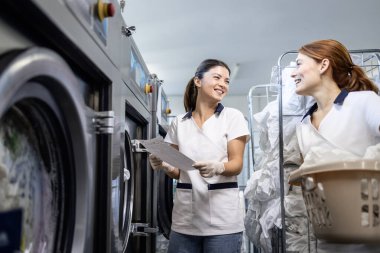 Çamaşırhanede birlikte çalışan kadın çalışanlar..