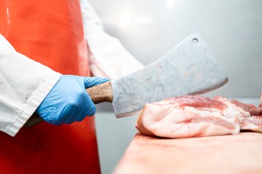 Deneyimli kasap ya da yiyecek fabrikası işçisi et dilimleyip satışa hazırlanıyor..