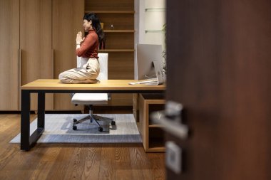 Güzel Asyalı kadın iş yerinde yoga egzersizleriyle vücudunu rahatlatıyor..