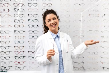 Satılık moda gözlük gösteren deneyimli bir bayan gözlükçü..