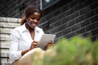 Tablet bilgisayarda çalışan takım elbiseli güzel siyah kız..