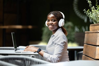 Cafe Bar 'da dizüstü bilgisayarla çalışan takım elbiseli zarif siyahi Afrikalı kadın..