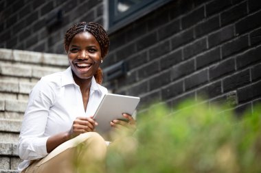Tablet bilgisayarlı mutlu gülümseyen iş kadını portresi.