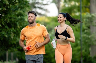 Formda ve sağlıklı insanlar parkta birlikte koşar ve doğanın tadını çıkarırlar..