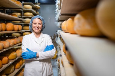 Peynir dolu raflarda duran fabrika yemekçisinin portresi..