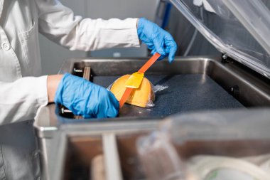 Endüstriyel gıda ambalajı. Steril giyimli işçiler gıda ürünlerini etiketliyor..