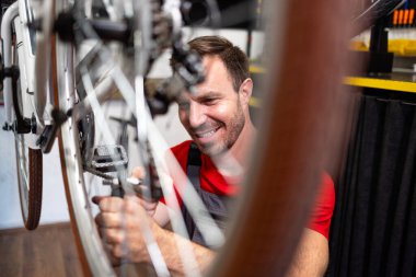 Profesyonel bisiklet atölyesinde vites ayarlama konusunda deneyimli bir tamirci..