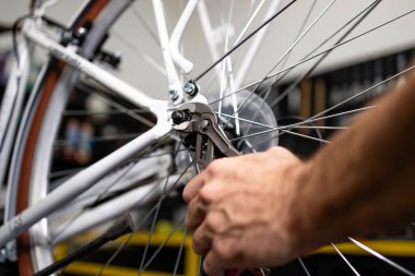 Bisikletin arka tekerleğini beceren askerin yakın görüntüsü. Bisiklet bakımı ve atölyesi.