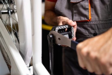 Bisiklette yeni pedallar takan profesyonel tamircinin yakın görüntüsü.