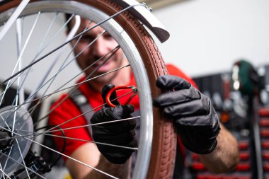 Profesyonel bisiklet tamircisi tekerlek tellerini tamir ediyor..