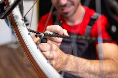 Kırık bisiklet zincirini tamir eden Kafkas askerinin portresi.