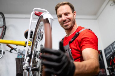 Profesyonel servis elemanı bisiklet çarkı döndürüyor ve dengeyi kontrol ediyor.