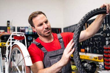 Bisiklet tamircisinin bisiklet atölyesinde yeni lastiği var..