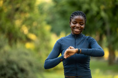 Dişi sporcu akıllı saati ve ocak fiyatıyla koşu mesafesini kontrol ediyor..