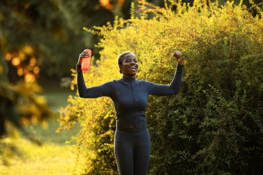 Eğitimden sonra kollarını kaldıran pozitif siyah atlet..