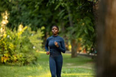 Parkta koşan Afrikalı Amerikalı kadın. Parkta koşan güzel siyah kadın..