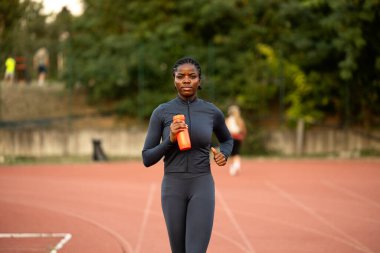 Profesyonel Afro-Amerikan bayan koşucu sıkı koşuyor ve eğitiyor..