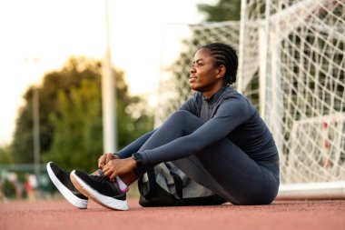 Siyah kadın koşucu ya da sporcu vücut çalışıp antrenmandan önce ısınıyor..