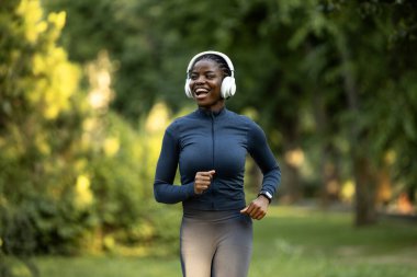 Siyah kadın dışarıda koşuyor. Parkta spor kıyafetleriyle koşan bayan sporcu..